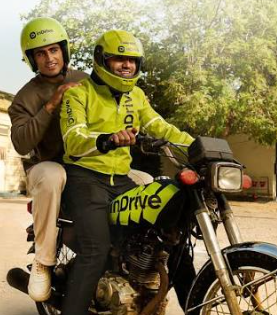 inDrive branded jacket and helmet on a motorbike rider